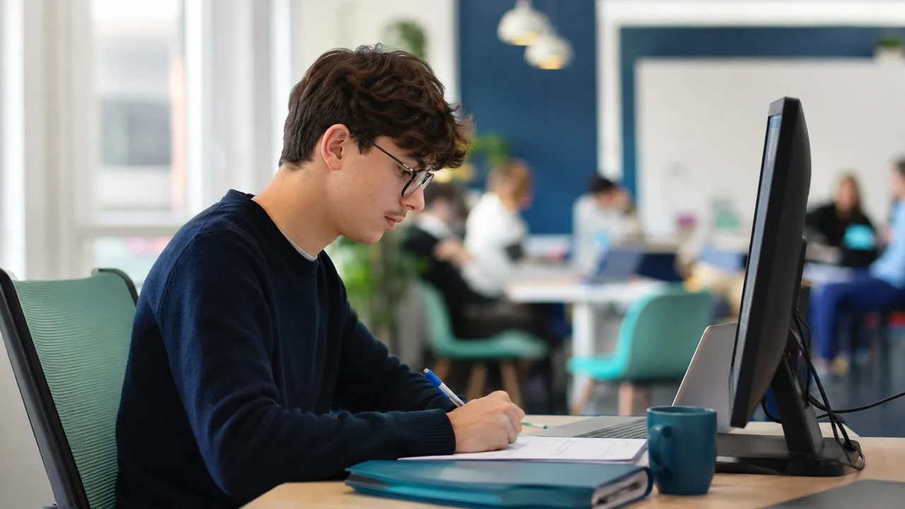 Une apprenante en alternance, entre son poste en entreprise et la salle de cours